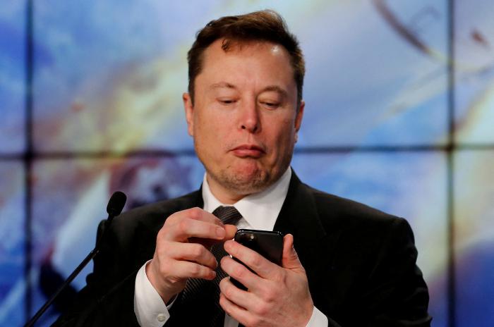 Elon Musk qui regarde son smartphone
