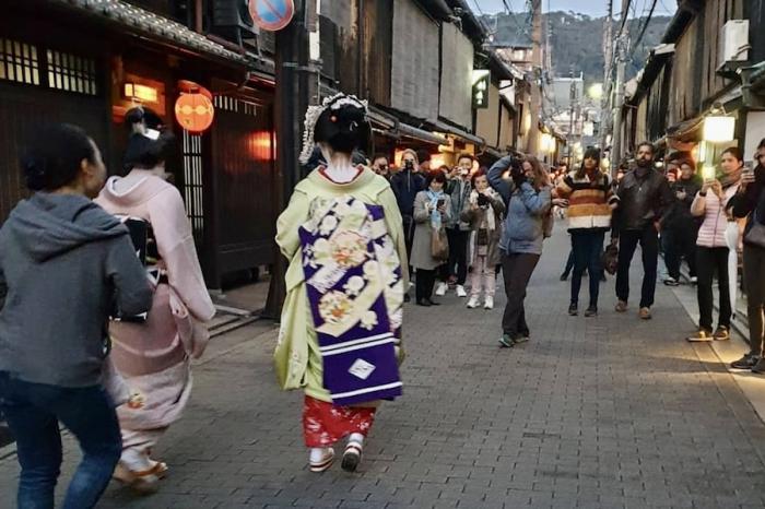 Des touristes photographient des geishas