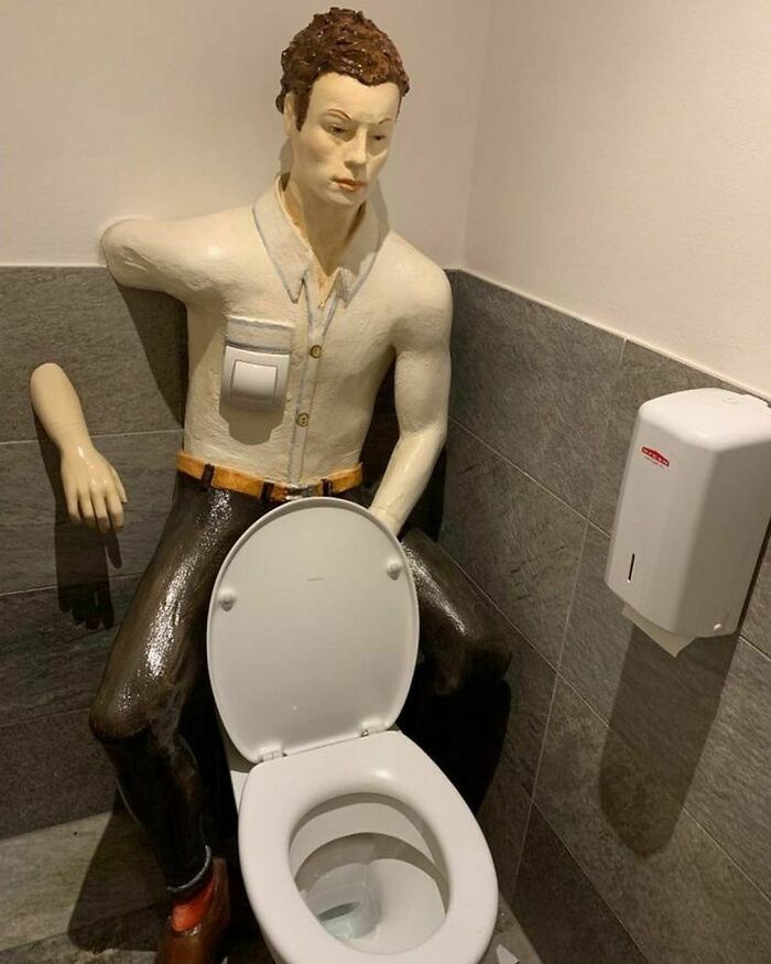 un homme derrière une WC