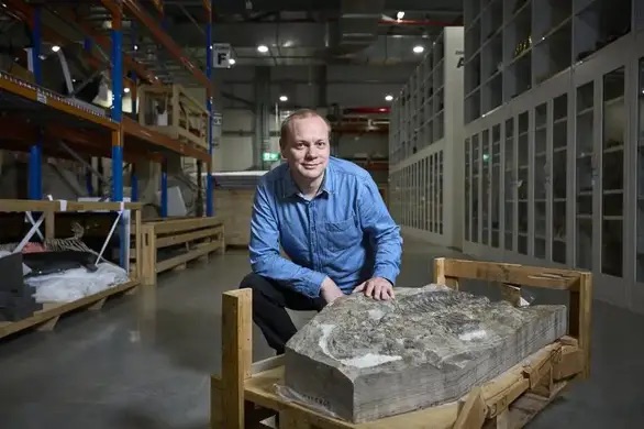 Le paléontologue Lachlan Hart devant le fossile d