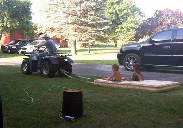 père tire enfants sur matelas