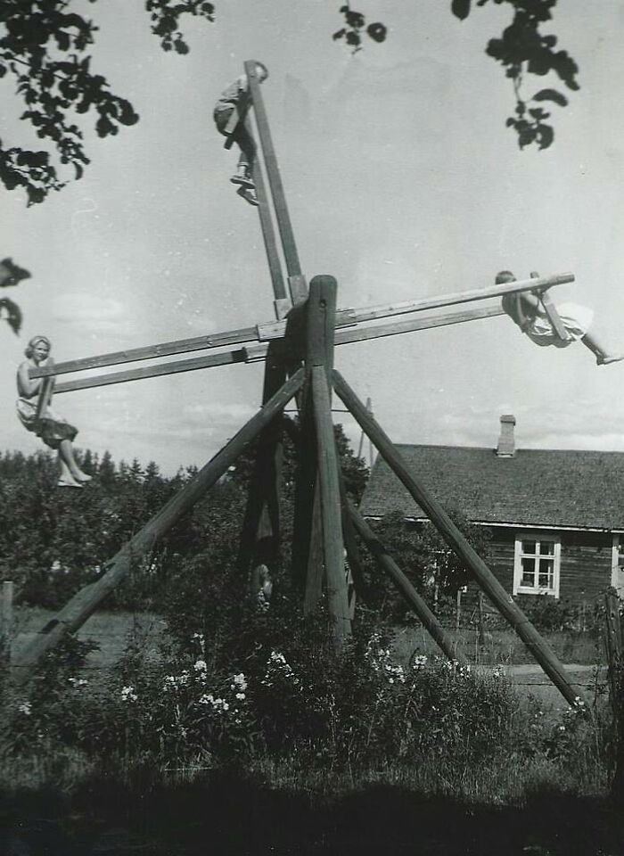 Une famille joue sur une balançoire maison unique pour quatre personnes en Finlande, 1954