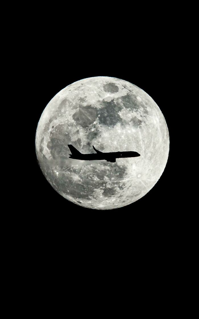 un avion qui passe devant la lune