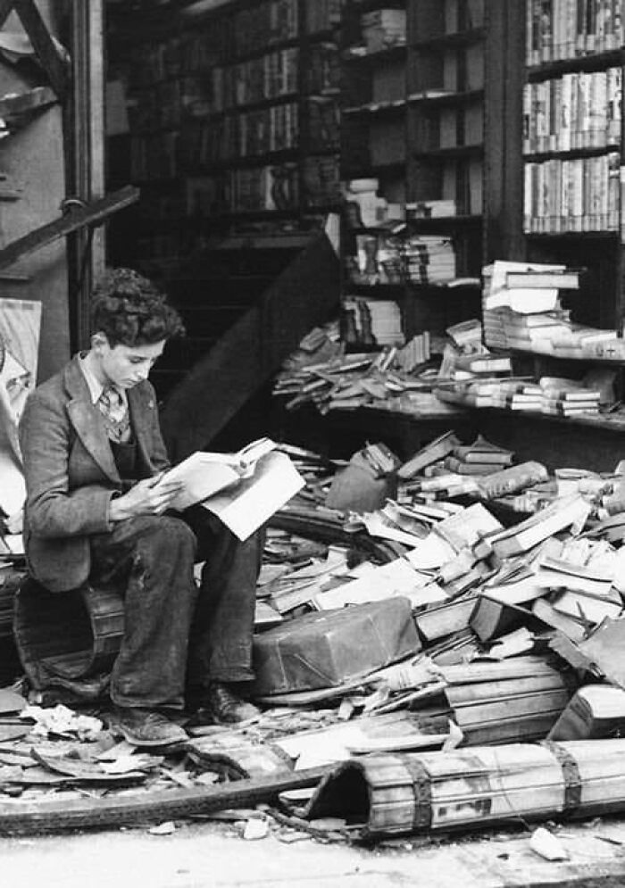 Un garçon lit dans une librairie bombardée, Londres, 1940