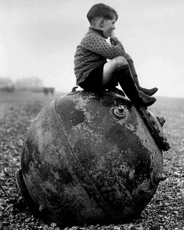 Un garçon assis sur une mine de mer dans le Kent, au Royaume-Uni, 1945