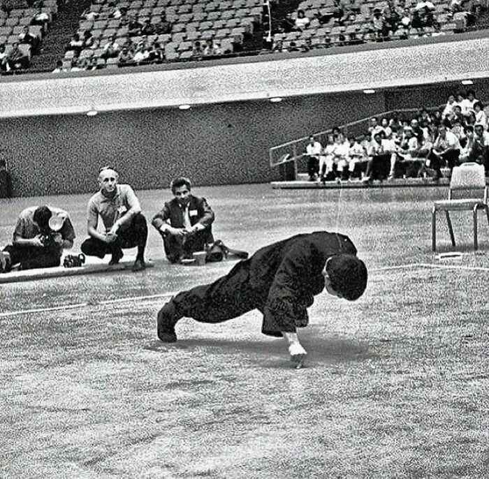 Bruce Lee en train de faire des pompes à 2 doigts dans les années 70