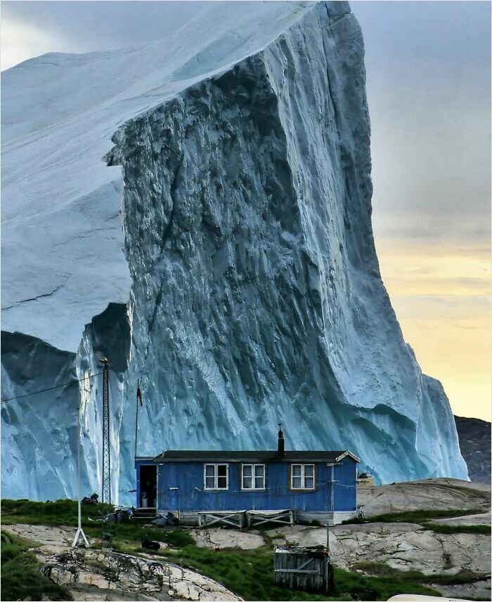 Iceberg qui passe près d’une maison au Groenland