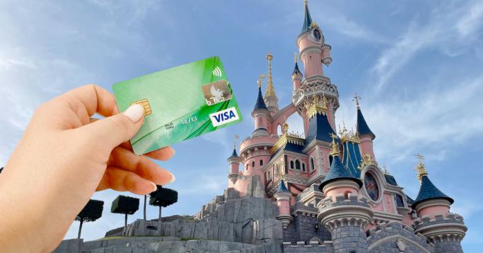 main avec carte visa devant chateau disneyland