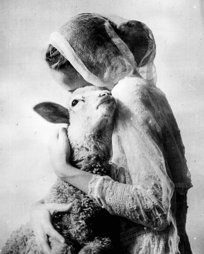 une femme avec un agneau dans les bras