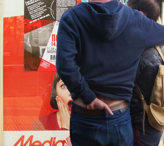 photo de rue avec un homme devant une affiche