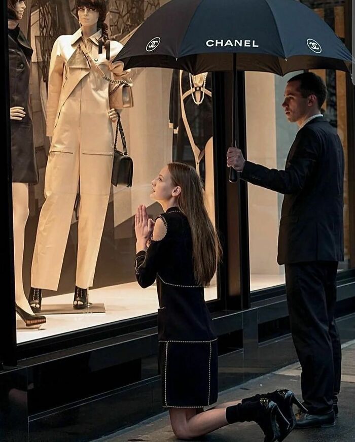 une femme en train de prier devant une boutique de luxe