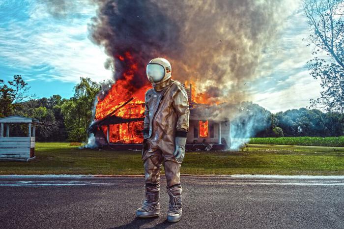 astronaute devant une maison en flamme